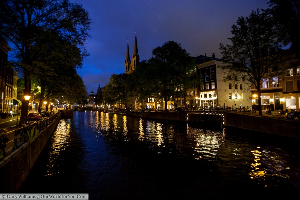 The Singel canal with the De Krijtberg Church piercing the skyline, Amsterdam, The Netherlands