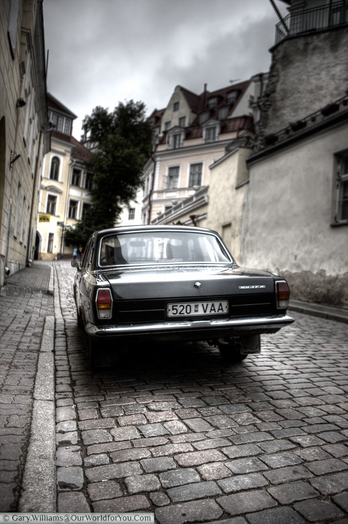 A picture of a Soviet era car parked up, set in a moody scene.