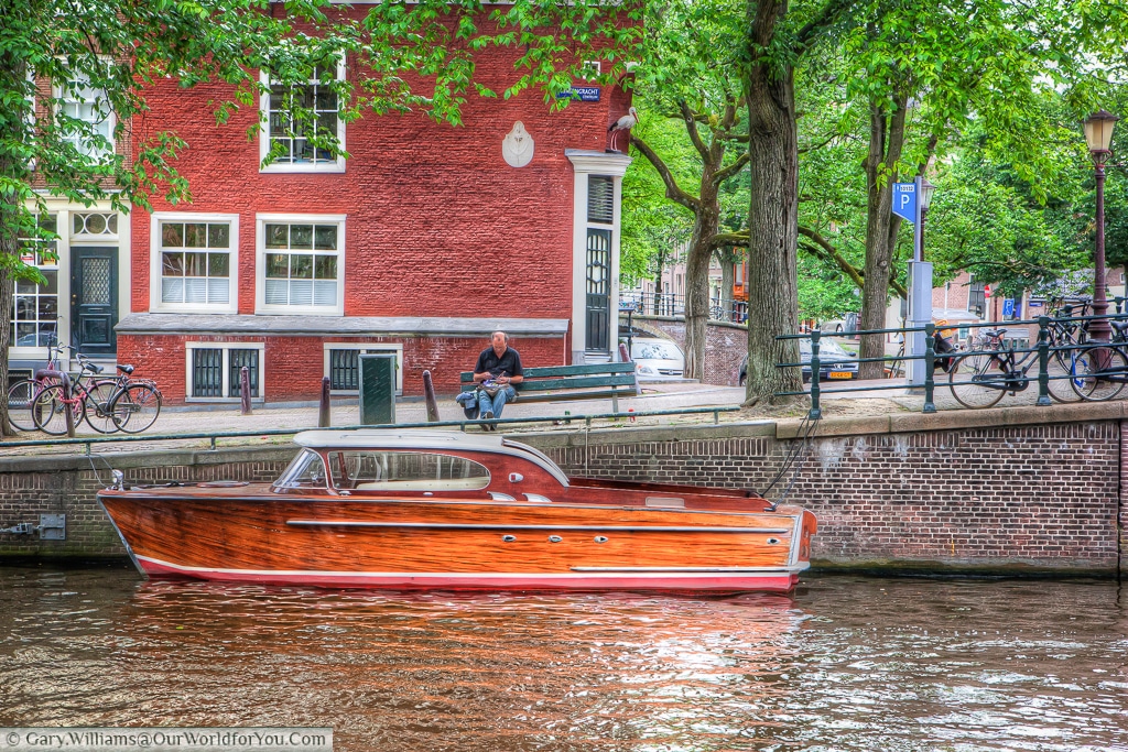 A wonderful wooden boat moored on the side of a canal in Amsterdam, The Netherlands