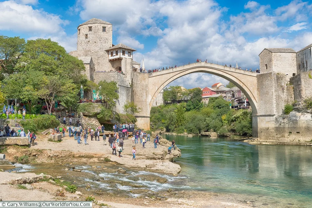 A stream joins the Neretva River, with the The Stari Most in the background, Mostar, Bosnia and Herzegovina