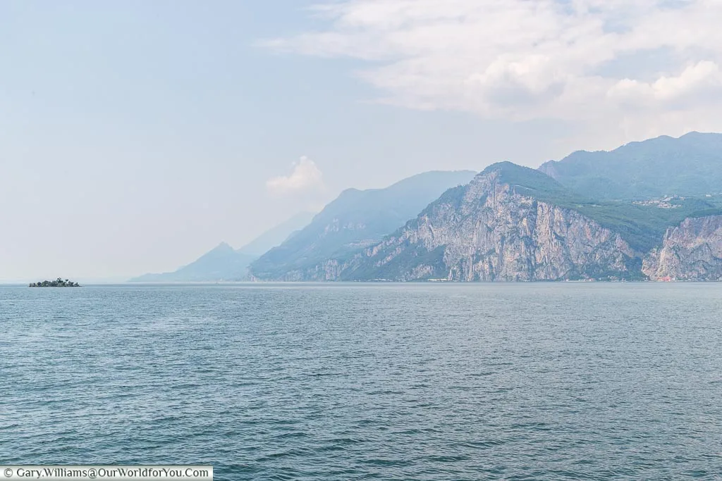A view of Lake Garda, the mountains on one side, taken whilst crossing on a ferry towards Malcesine.