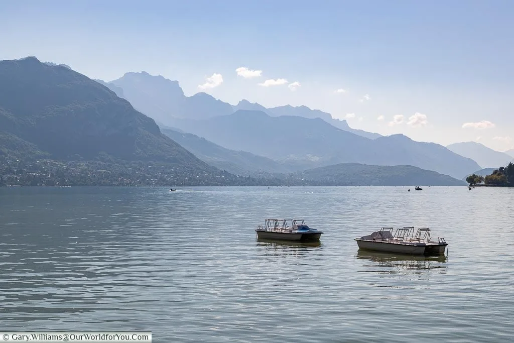 Two boats on a hazy Lake Annecy.