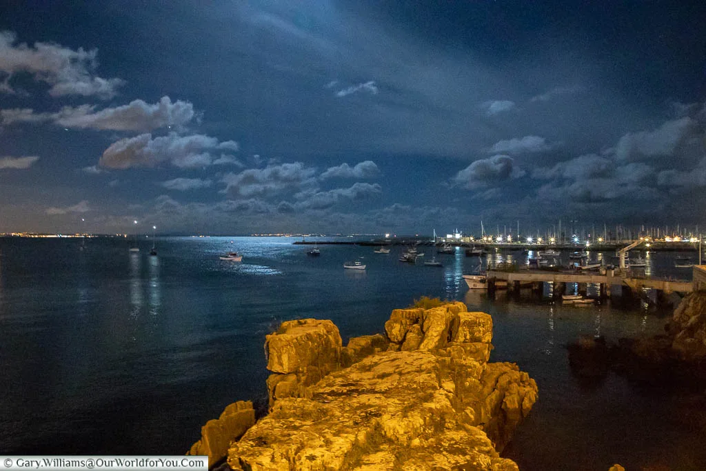 The view from the small beach of Praia da Rainha overlooking Cascais at night