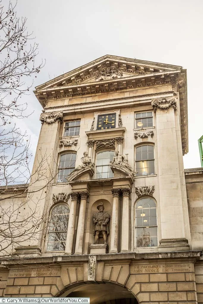 The 18th-century stone Henry VIII gatehouse, leads to St Bart's Hospital, with its statue of the King and offices and a clock.