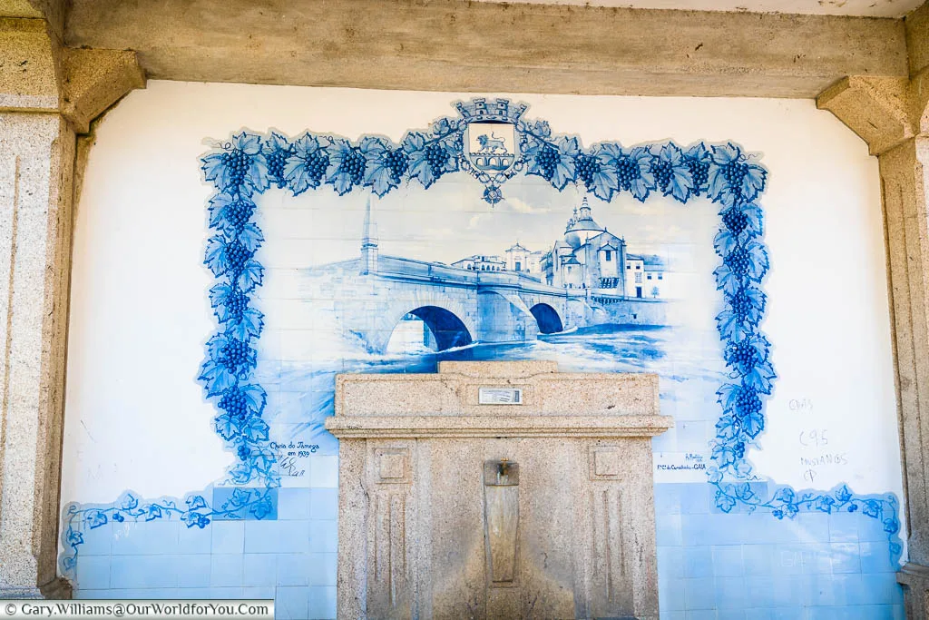 A blue and white tiled image of the Ponte de São Gonçalo in front of the church in Amarante, Portugal