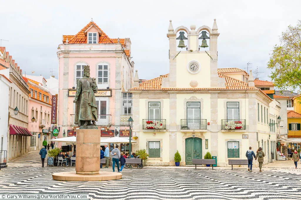 The Praca 5 de Outubro tiled in black and white with historic buildings lining this square in Cascais, Portugal
