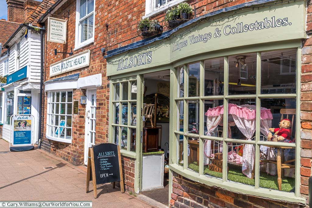 An antiques and collectables shop on the High Street in Headcorn with teddy bear and a small child's bed in the window