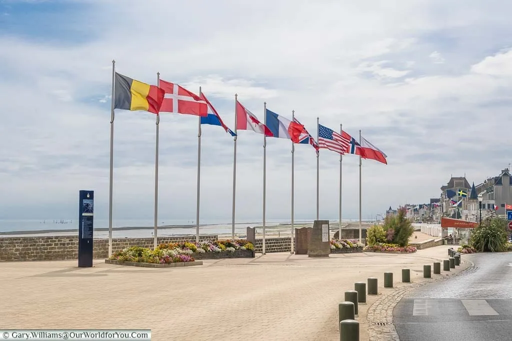 9 flagpoles, with 9 different allied flags fluttering in the wind at Courseulles-sur-Mer, overlooking 'Juno' beach in Normandy