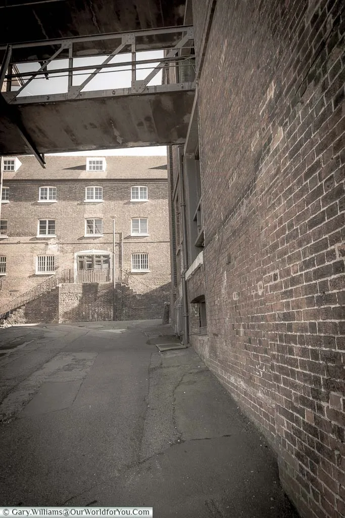 Quiet lanes between brick-built warehouse buildings of Chatham Dockyard that double as different locations & different periods in plenty of movies.