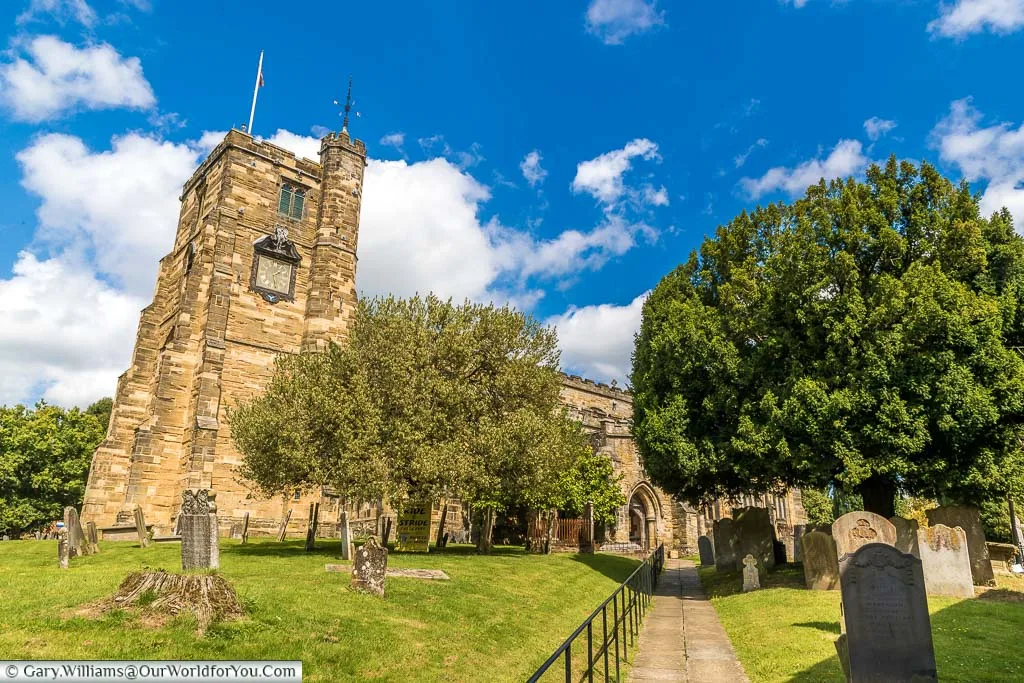 Walking the path between the gravestones towards the main entrance of Saint Dunstan's church in Cranbrook on a beautiful sunny day