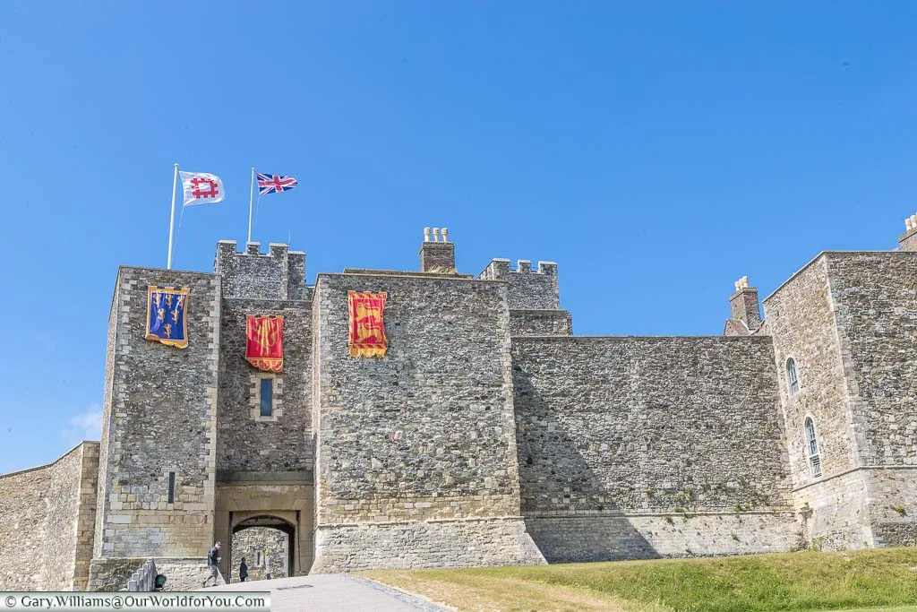 Dover Castle's outer walls draped with the standards of Henry II, and flying the flags of English Heritage & the Union Flag.
