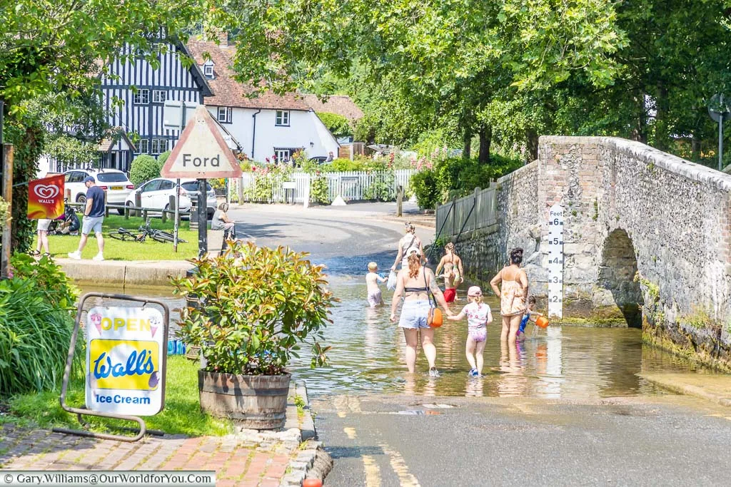 A mothers & children wading in the ford, next to the old stone bridge, at Eynsford in Kent