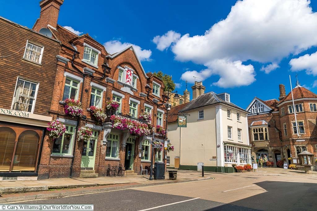 The White Horse public house takes pride of place in the High Street of Cranbrook. The windows are decorated with brightly coloured hanging baskets.