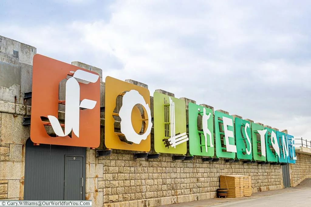An art installation spelling out Folkestone on brightly coloured tiles on the wall of the harbour arm.