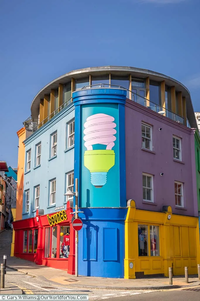 A mural of a brightly painted low energy light bulb painted on a building at the base of the Creative Corner end of the Old High Street in Folkestone