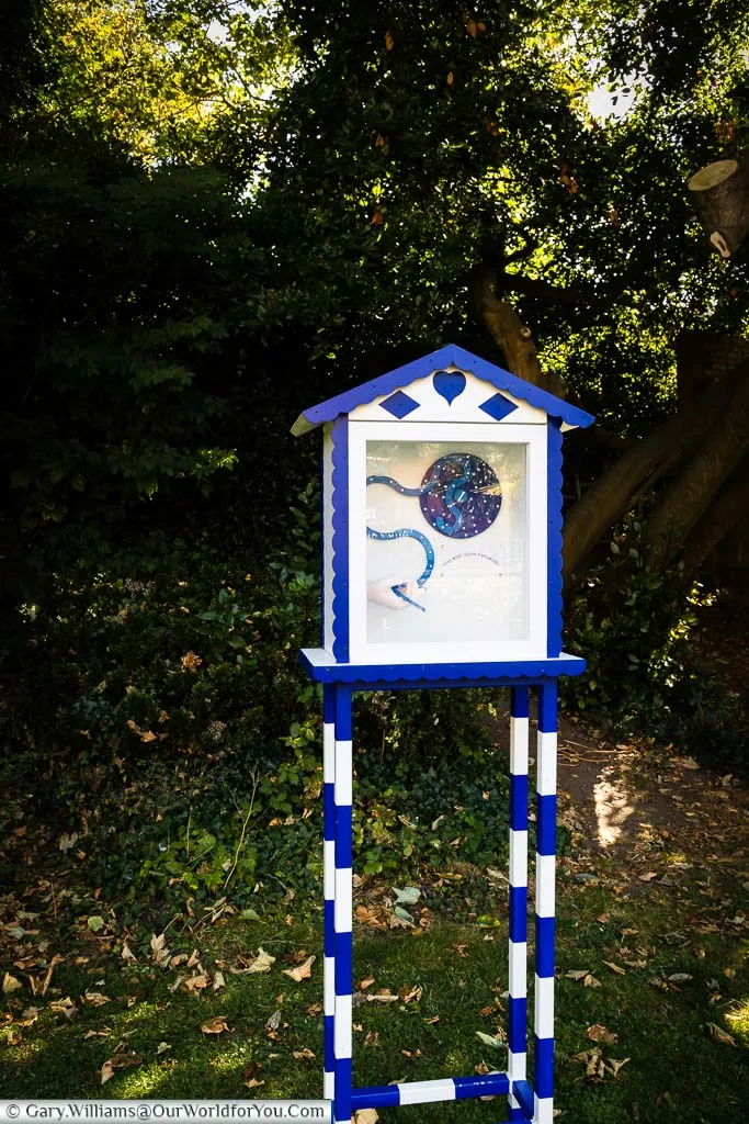 A blue and white wooden and glass box in the Bayle Pond which is part of the 'On the Track of St. Eanswythe’s Waterway' art installation in Folkestone