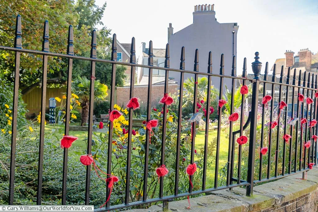 Knitted poppies attached to the iron railings of the Bayle Pond in Folkestone, Kent