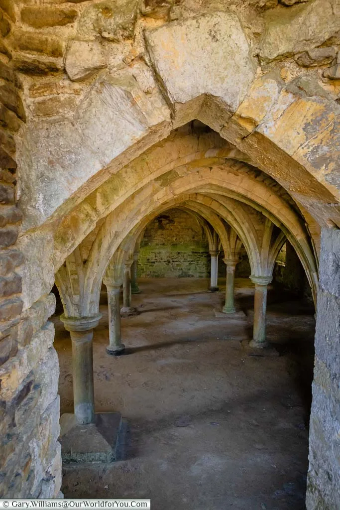 Looking down into the space under the dormitory with its low vaulted ceiling.