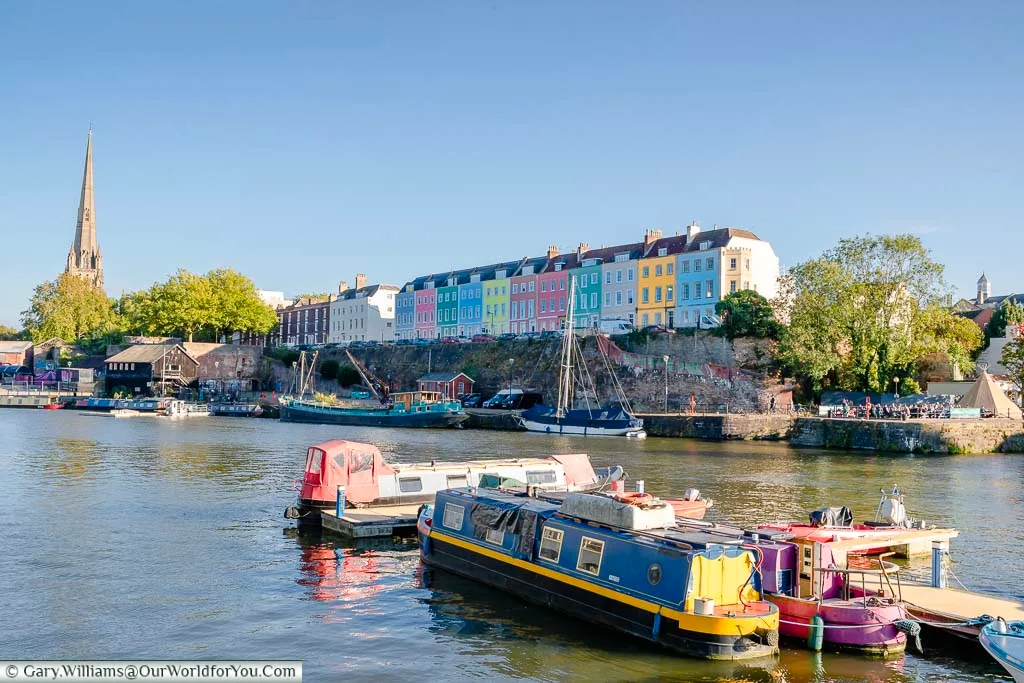 Looking over Bristol Harbour to the colourful houses of Redcliffe Parade with the spire of St Mary Redcliffe Church in the distance.
