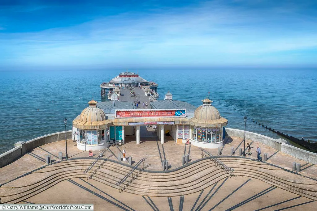 Looking down from the clifftop promenade to the elegant Cromer Pier reaching out to sea on a bright summer's day.