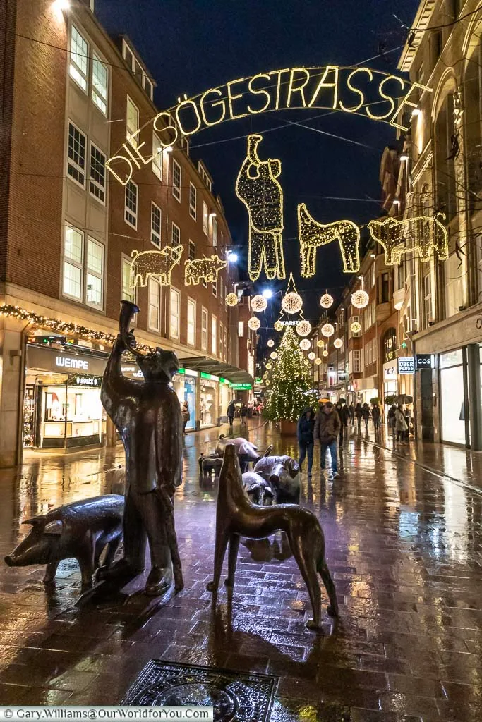 A collection of bronze statues in Sögestrasse, Bremen, that represents a pig farmer and his drove of pigs.