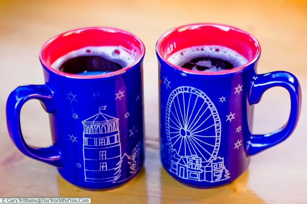 Two blue mugs of glühwein with features from Düsseldorf's Christmas Village