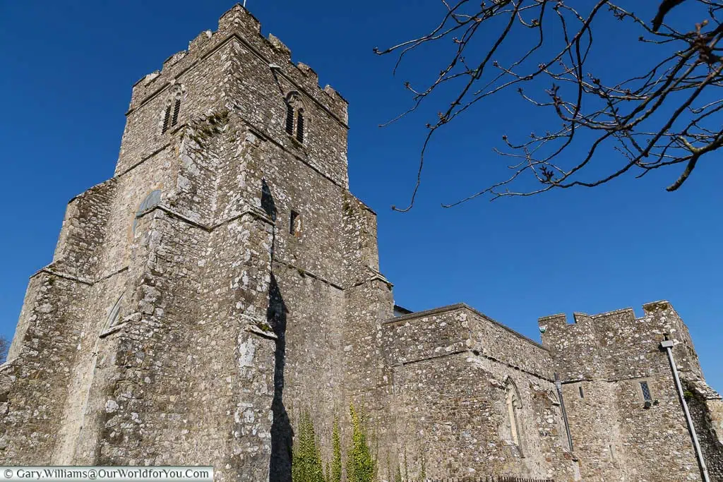 Looking up at the stone bell tower of St George's Church, Ivychurch on the Romney Marsh in Kent