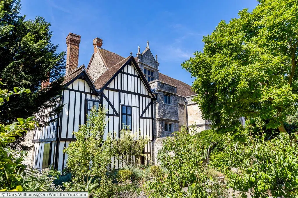 The Tudor end of the Archbishop's Palace in Maidstone from the Archbishop’s Apothecary Garden under blue skies.