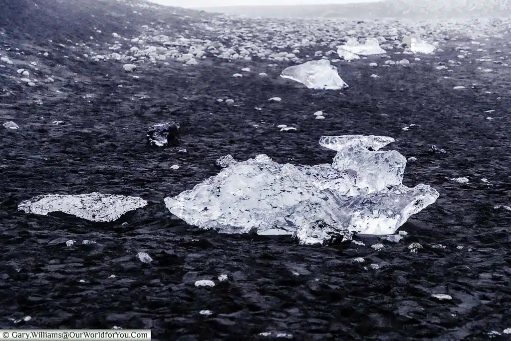 Lumps of crystal clear ice washed up on the jet black sand of Diamond Beach