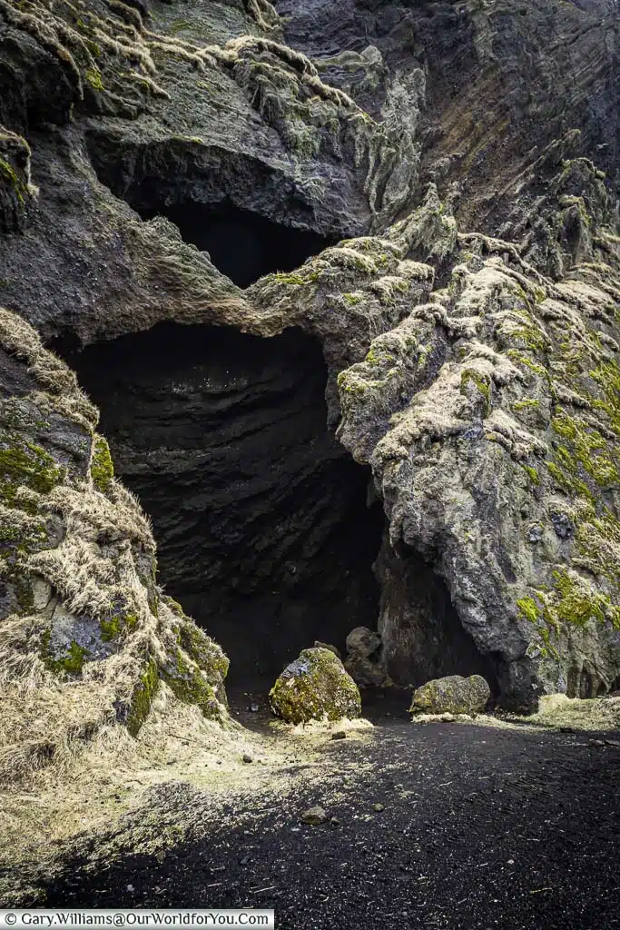 The entrance to the Hjörleifshöfði cave formed within the harsh rock face