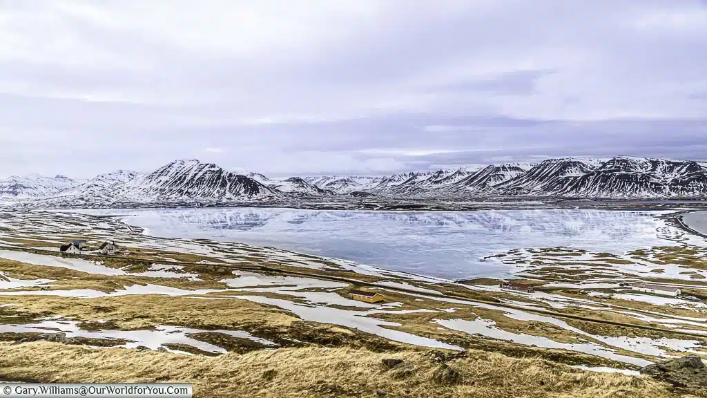 A mirrored view of a mountain range in the frozen Miklavatn lake in Northern Iceland