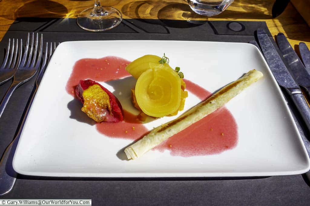 The second course a crispy roll with goats cheese & three ways beetroots on a plain white plate. The cutlery is magnetic so stays in place as you make your way through London