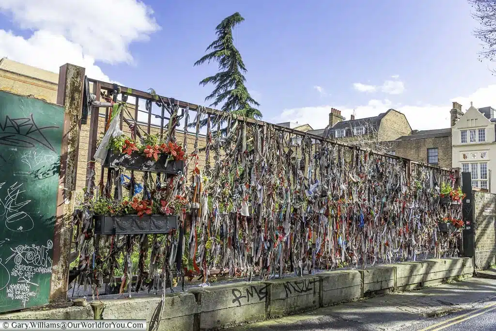 The railings of Bankside's Crossbones Graveyard adorned with memorial ribbons for the souls remembered in the cemetery in London