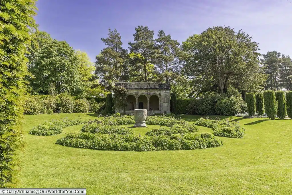 A circular sunken garden in front of a stone loggia at nymans house and gardens in west sussex