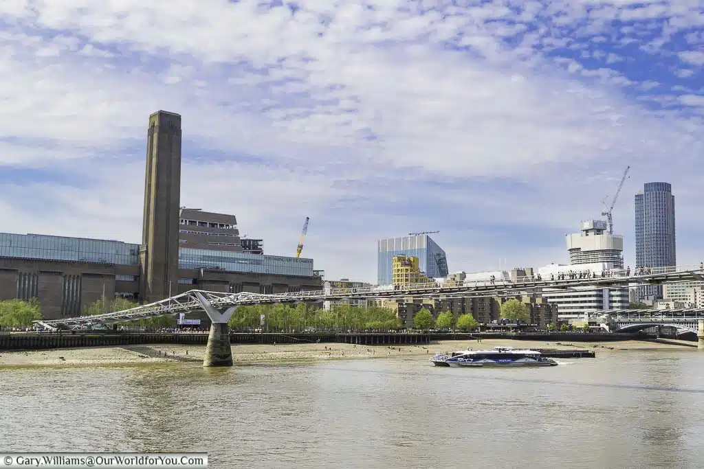 The tate modern on london's bankside as seen from the northside with the millennium bridge in the foreground