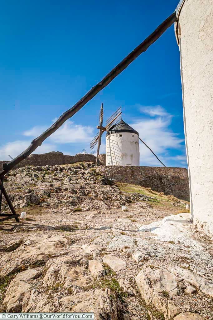 The view of one of the ancient windmills in consuegra in the rocky landscape of la mancha, spain