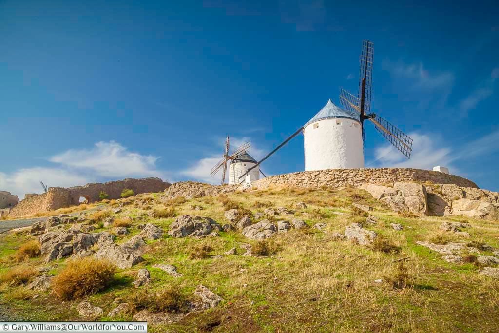 A view up the hillside to two ancient windmills at consuegra in central spain