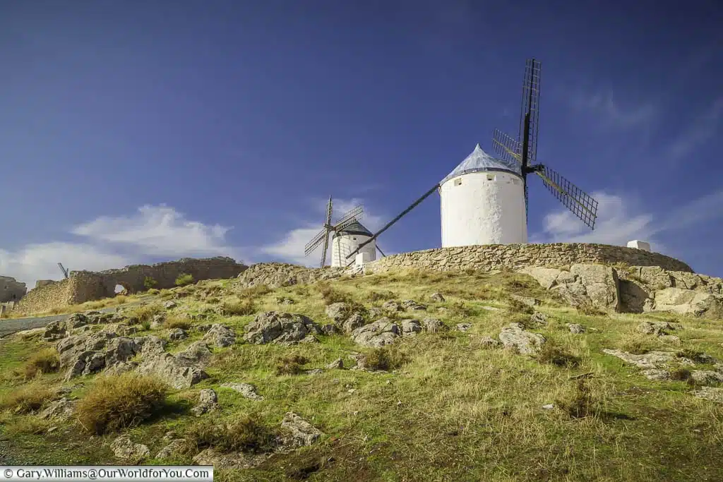 A view up the hillside to two ancient windmills at consuegra in central spain