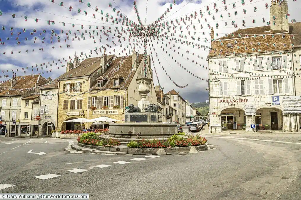 The fountain, acting as a roundabout in the centre of Arbois. Bunting leads from all corners of the square to meet at the fountain.
