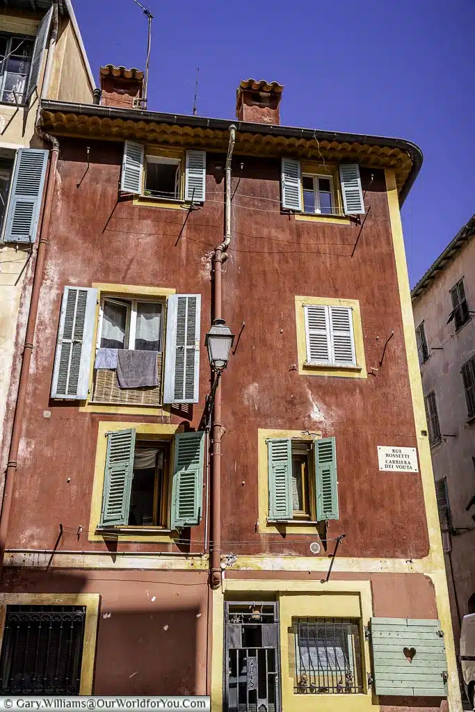 A bright red traditional apartment with green shutters in central nice