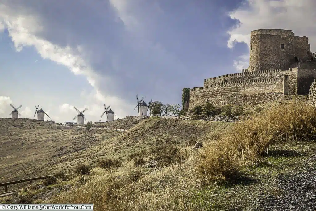 The view up the hill from consuegra castle with five ancient windmills of la mancha in the distance