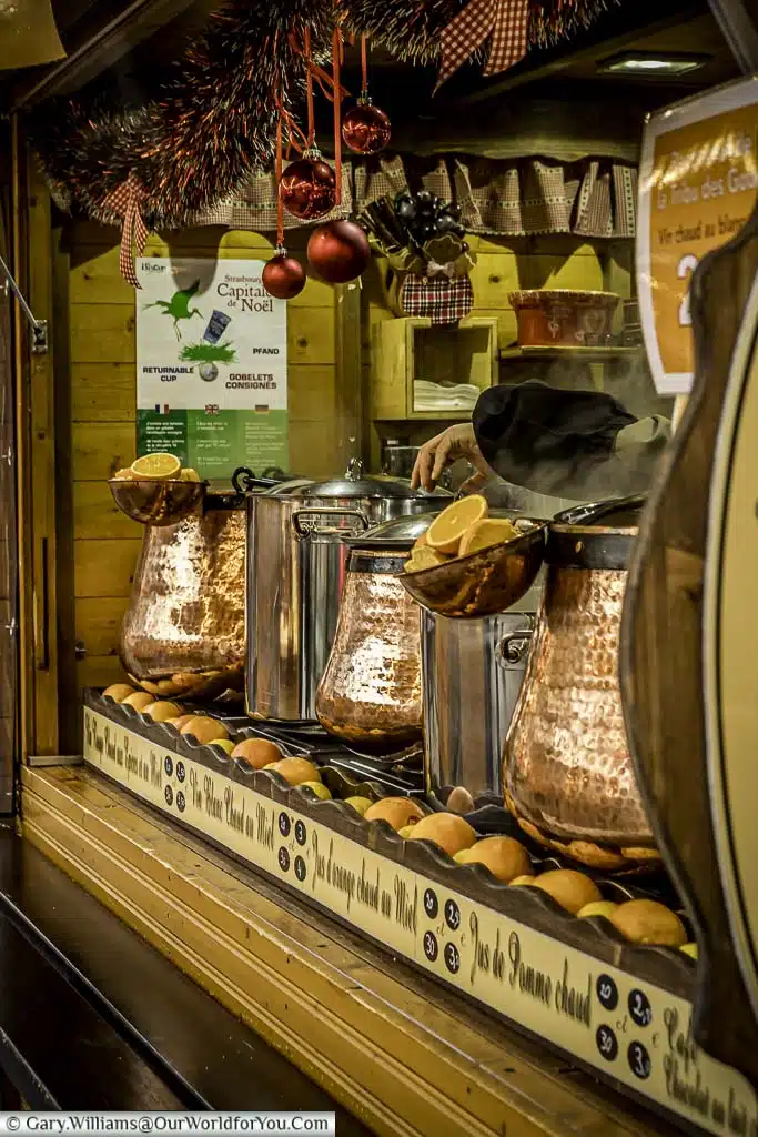 A view of a Christmas market stall with copper caldrons full of vin chaud.