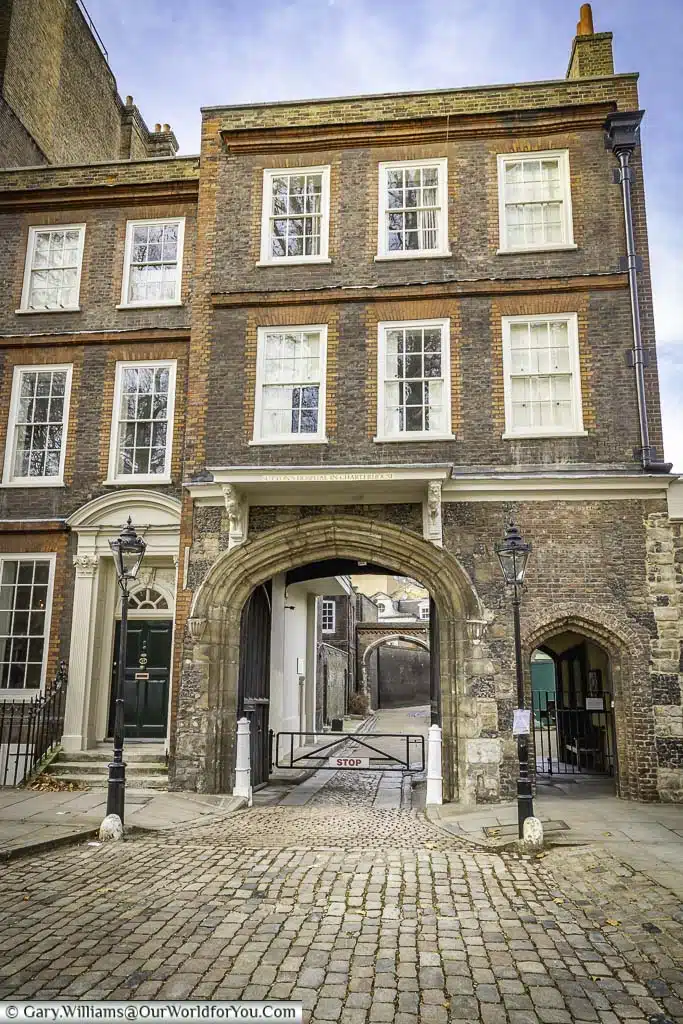 charterhouse gate, a stone archway with a red brick building over the top on the edge of London charterhouse