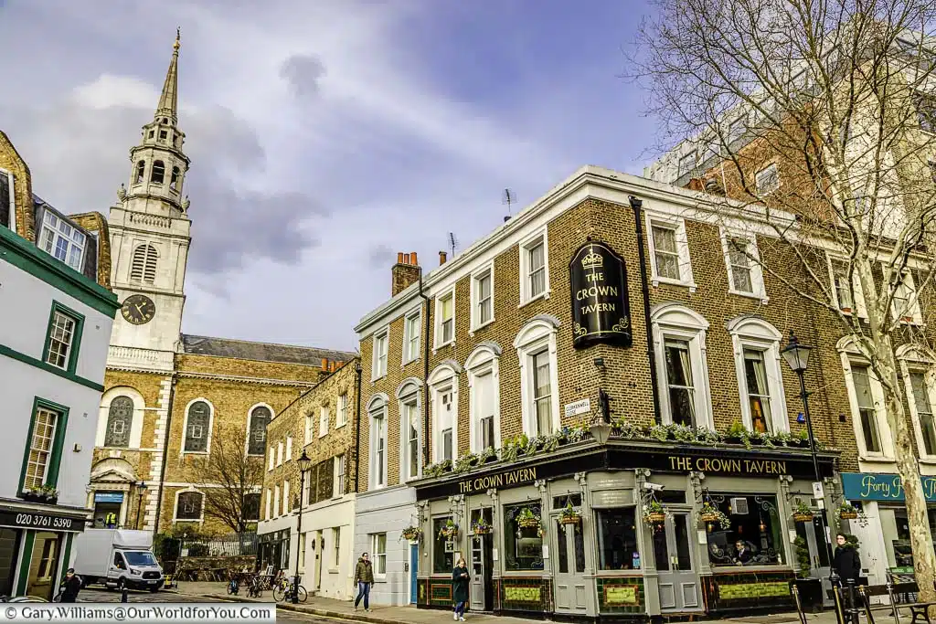 A street scene from Clerkenwell, East London, featuring the Crown Tavern and church in the background.