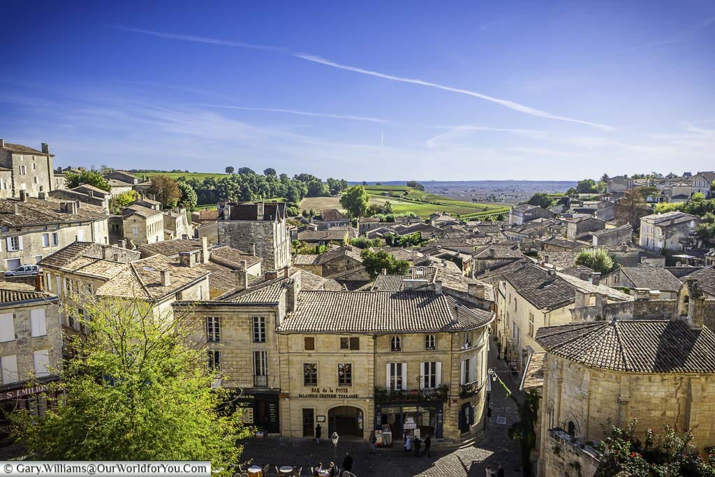 Looking over the stone buildings in the centre of old St-Emillion, with a view to the vineyards of the Bordeaux wine region beyond