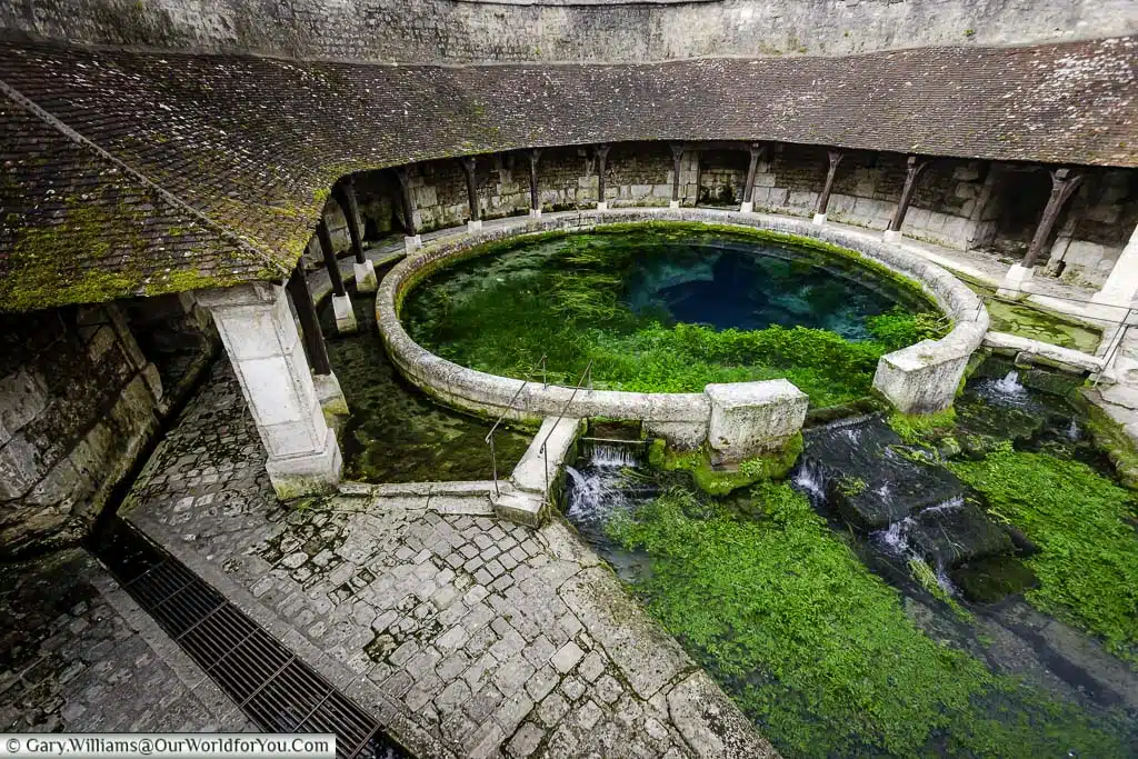 the fosse dionne natural spring that feeds an historic public wash stand in the medieval fench town of tonnerre