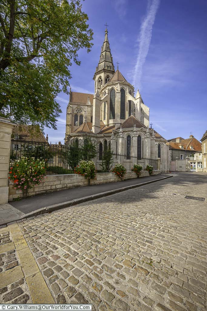 The view of the Collégiale Notre-Dame along a cobbled lane and the top of the semur-en-auxois in the burgundy region of france
