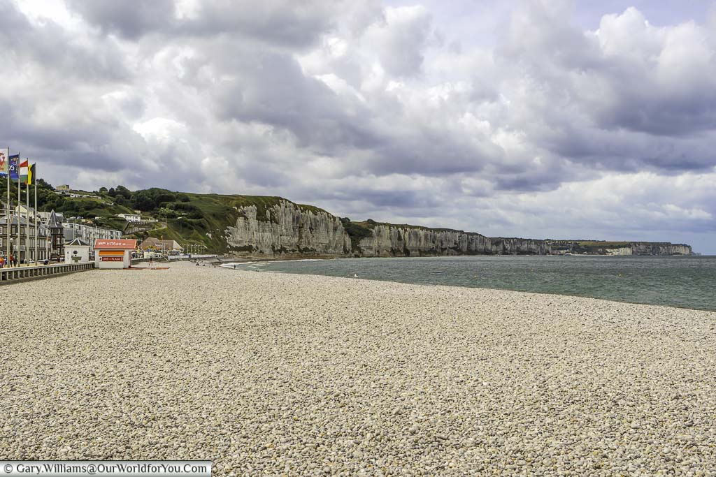 The gravel shoreline with white cliffs in the background of fecamp, in the normandy region of france