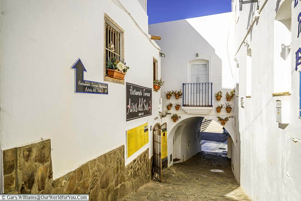 A low archway at the end of a narrow cobbled lane between the white home in old town mojácar, andalucia, spain