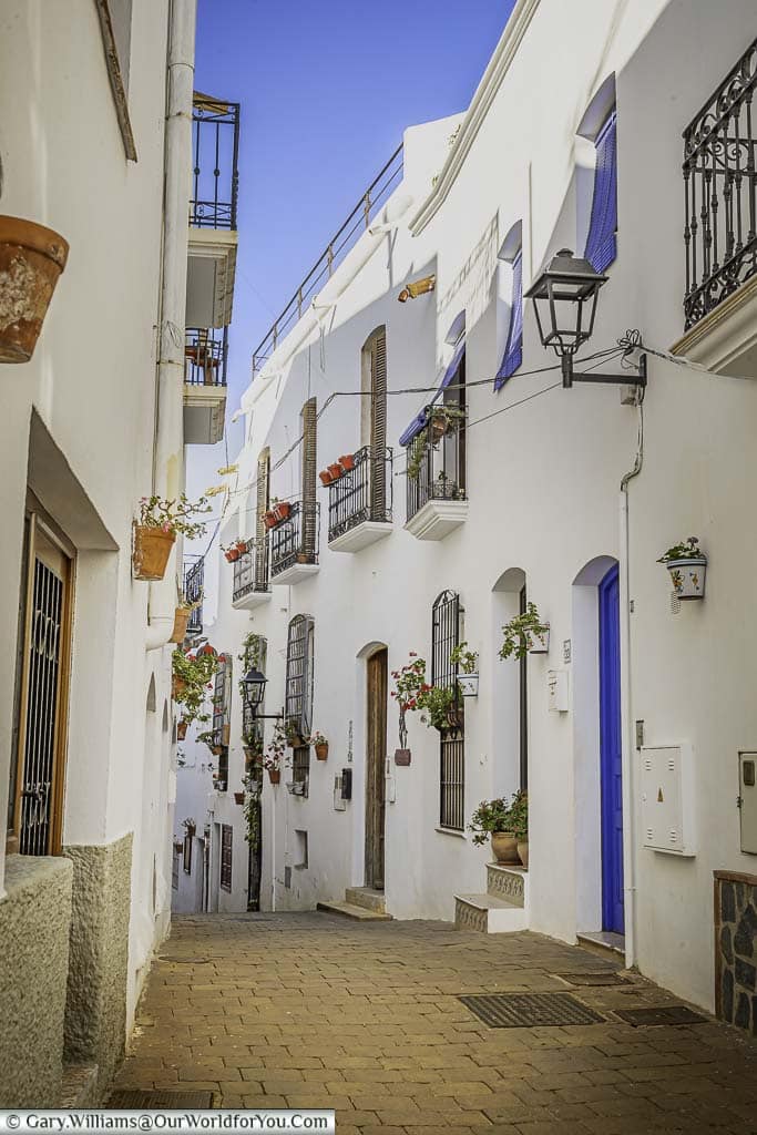 A narrow cobbled lane between the white home in mojácar old town, andalucia, spain